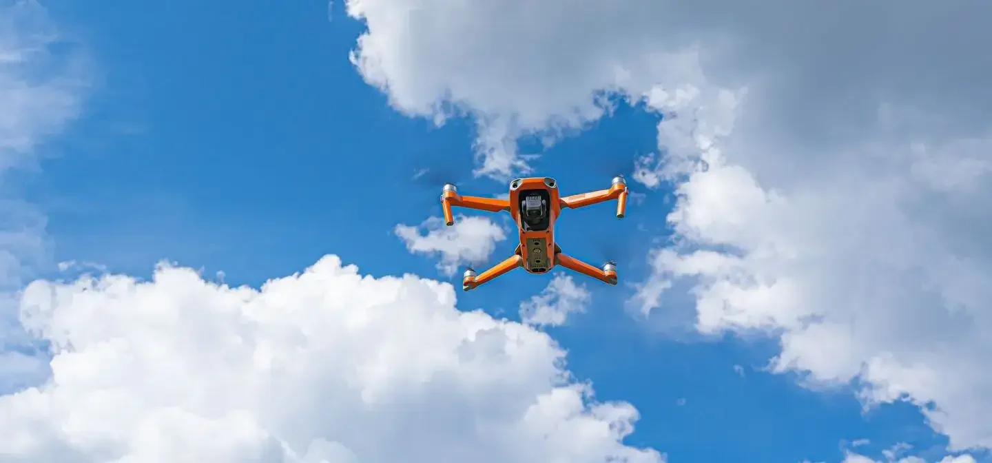 Drohne im Flug vor bewölktem Himmel